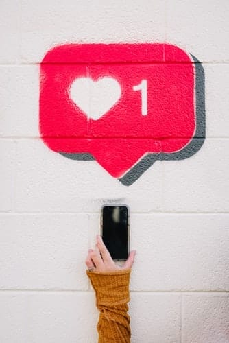 A person displays a phone featuring a heart symbol, representing customer appreciation in business efficiency strategies.