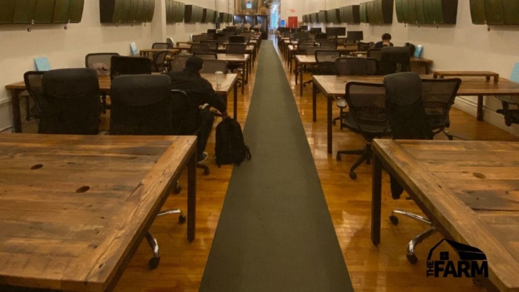 An elongated hallway with tables and chairs, ideal for fostering productivity while working remotely at Farm Soho.