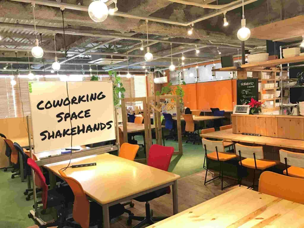 A large, open coworking space filled with tables and chairs, perfect for fostering creativity and collaboration in Tokyo.