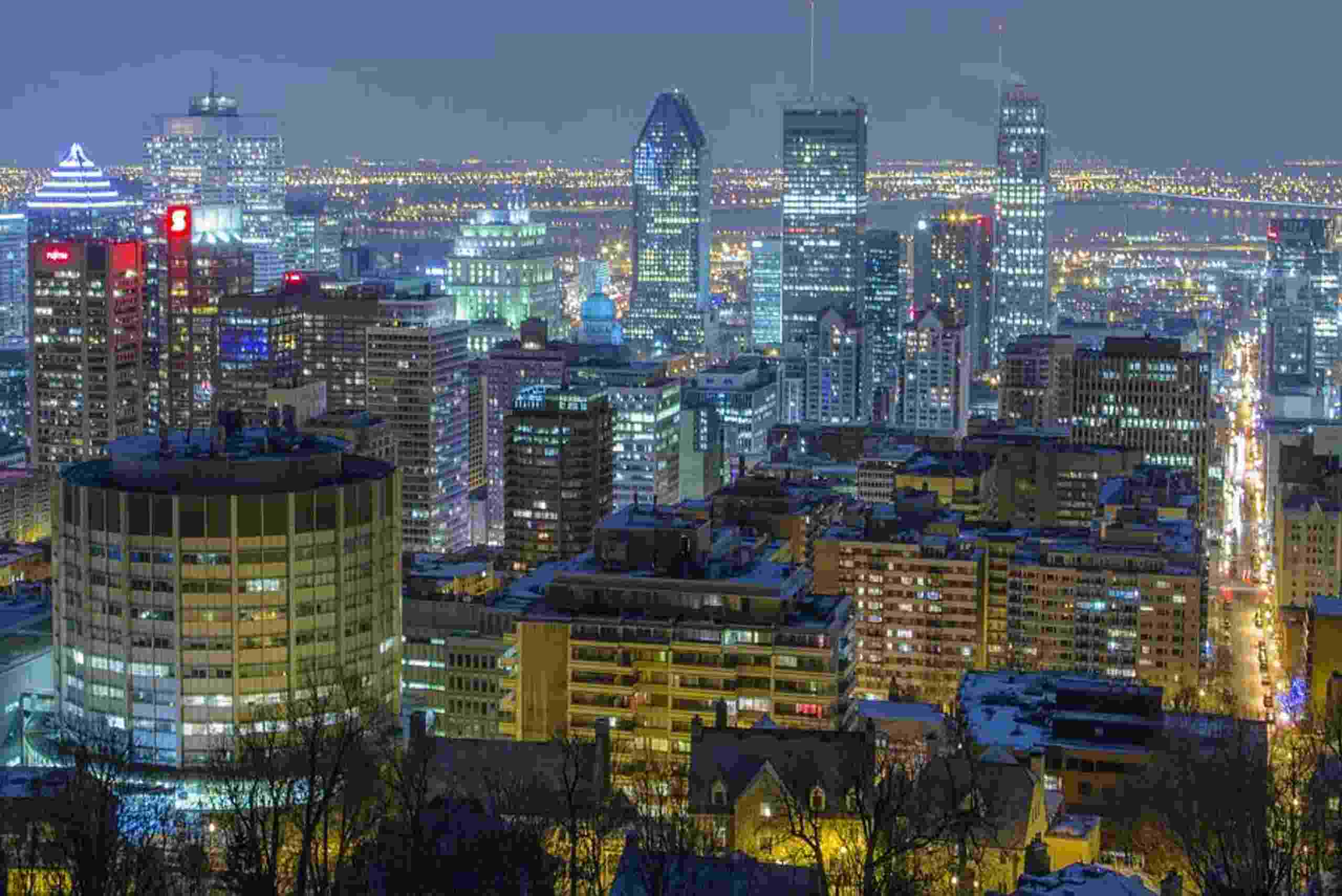 A nighttime panorama of Montreal, featuring the city's bright lights and dynamic urban landscape.