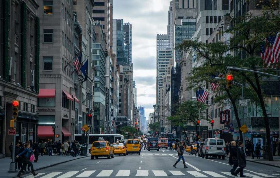 A lively city street in NYC, featuring pedestrians and vehicles, representing the dynamic atmosphere for event venues.