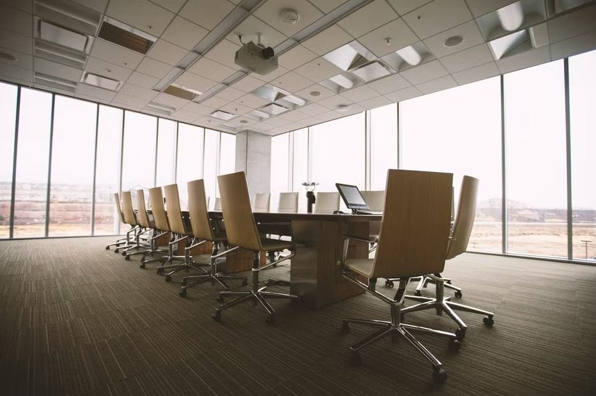 A spacious conference room featuring chairs arranged around a large window, ideal for business meetings and discussions.