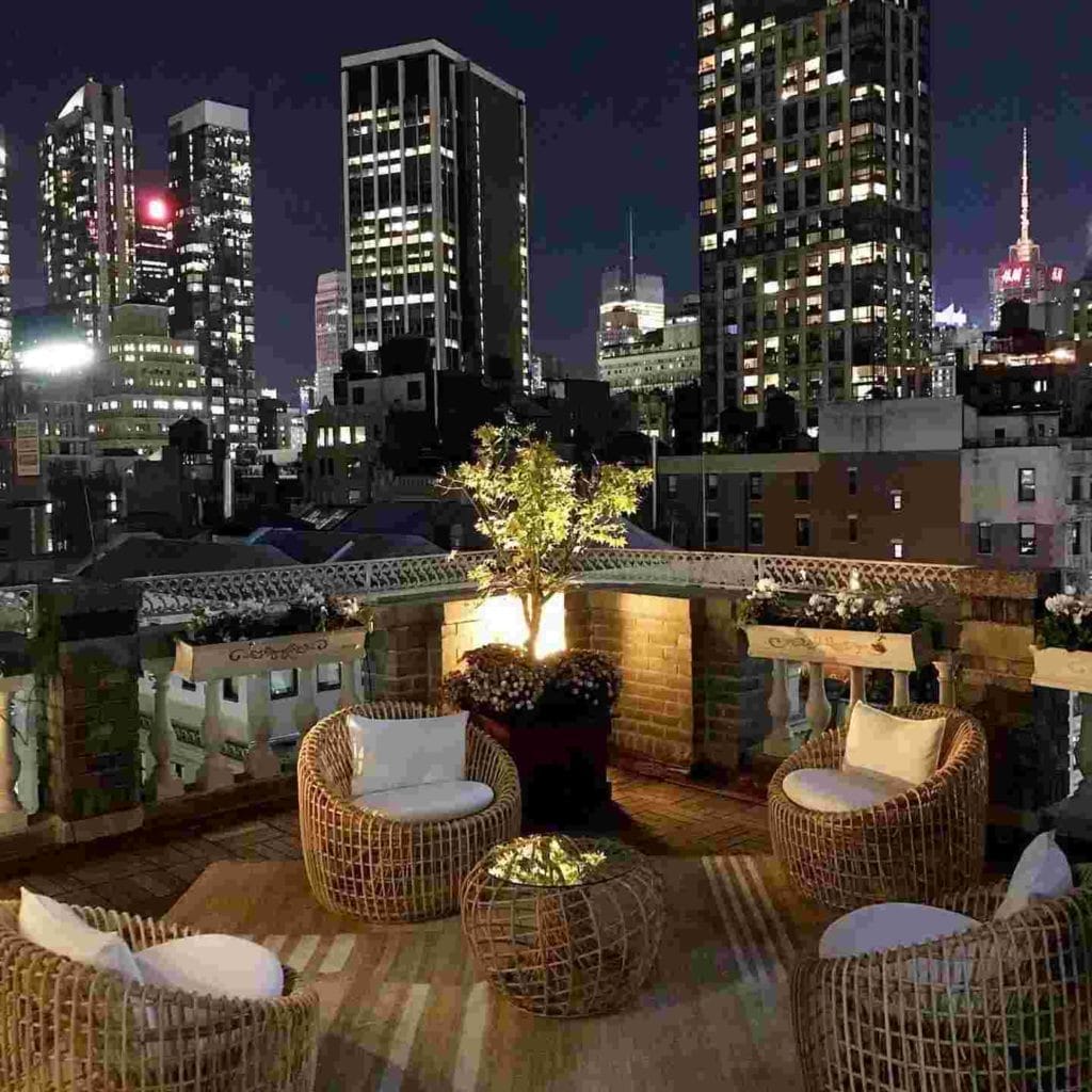 Rooftop terrace with wicker seating, showcasing a picturesque city view, ideal for events in Midtown Manhattan.