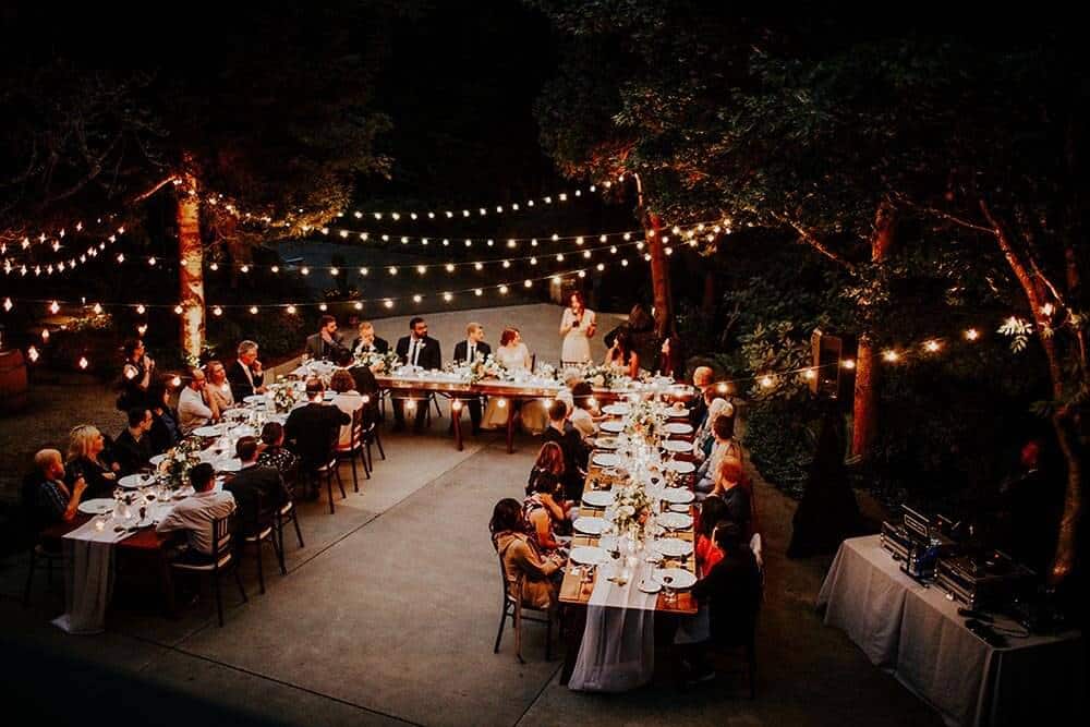A beautifully decorated outdoor wedding reception featuring string lights, enhancing the festive ambiance for the celebration.