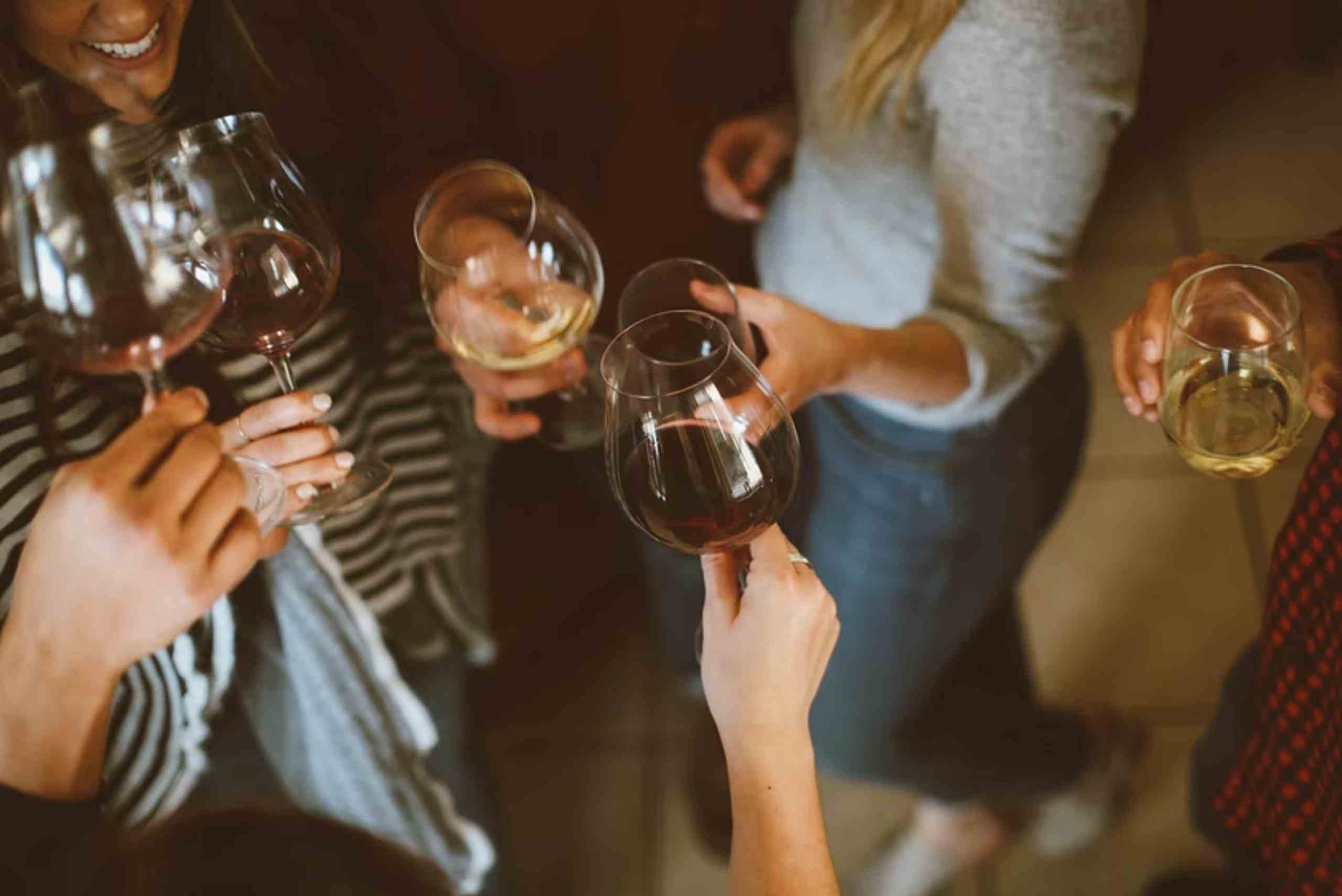 A diverse group of individuals joyfully toasting with wine glasses at a celebratory event in Seattle.