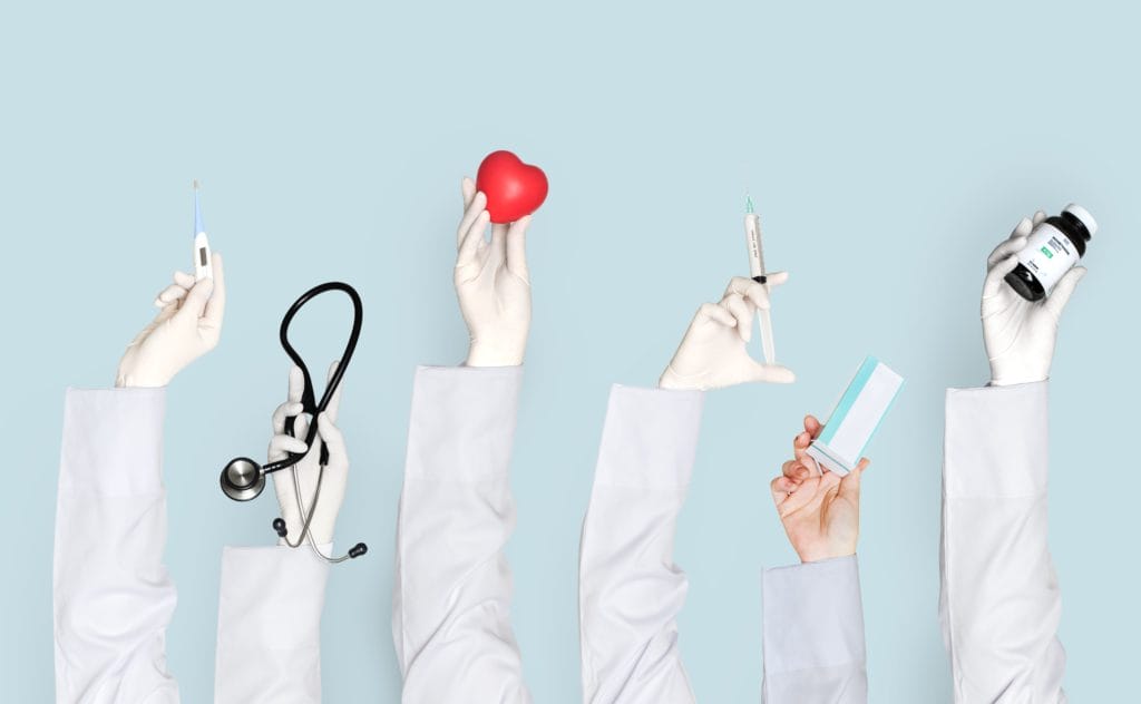 A diverse group of doctors proudly displaying an array of medical supplies, symbolizing innovation in healthcare.