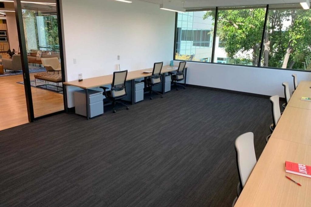 A vacant office environment with tables and chairs, highlighting the sleek interior of Venture X coworking space in California.