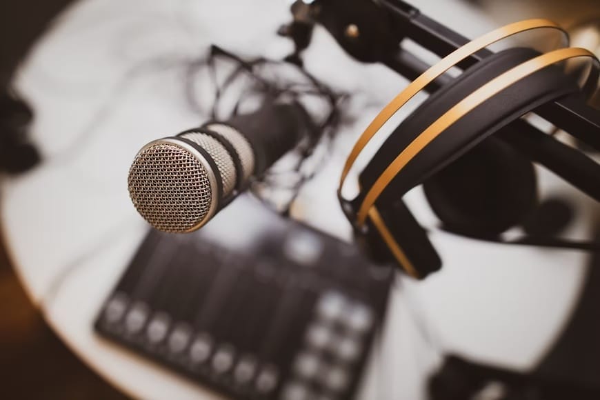 A microphone and headphones placed on a table, symbolizing the essence of podcast advertising and audio content creation.