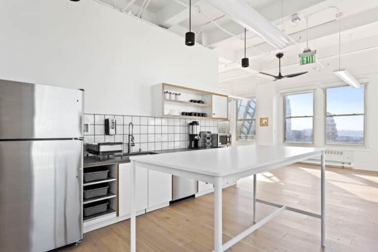 A modern kitchen featuring a white table and white appliances, located at 166 Geary St, San Francisco.