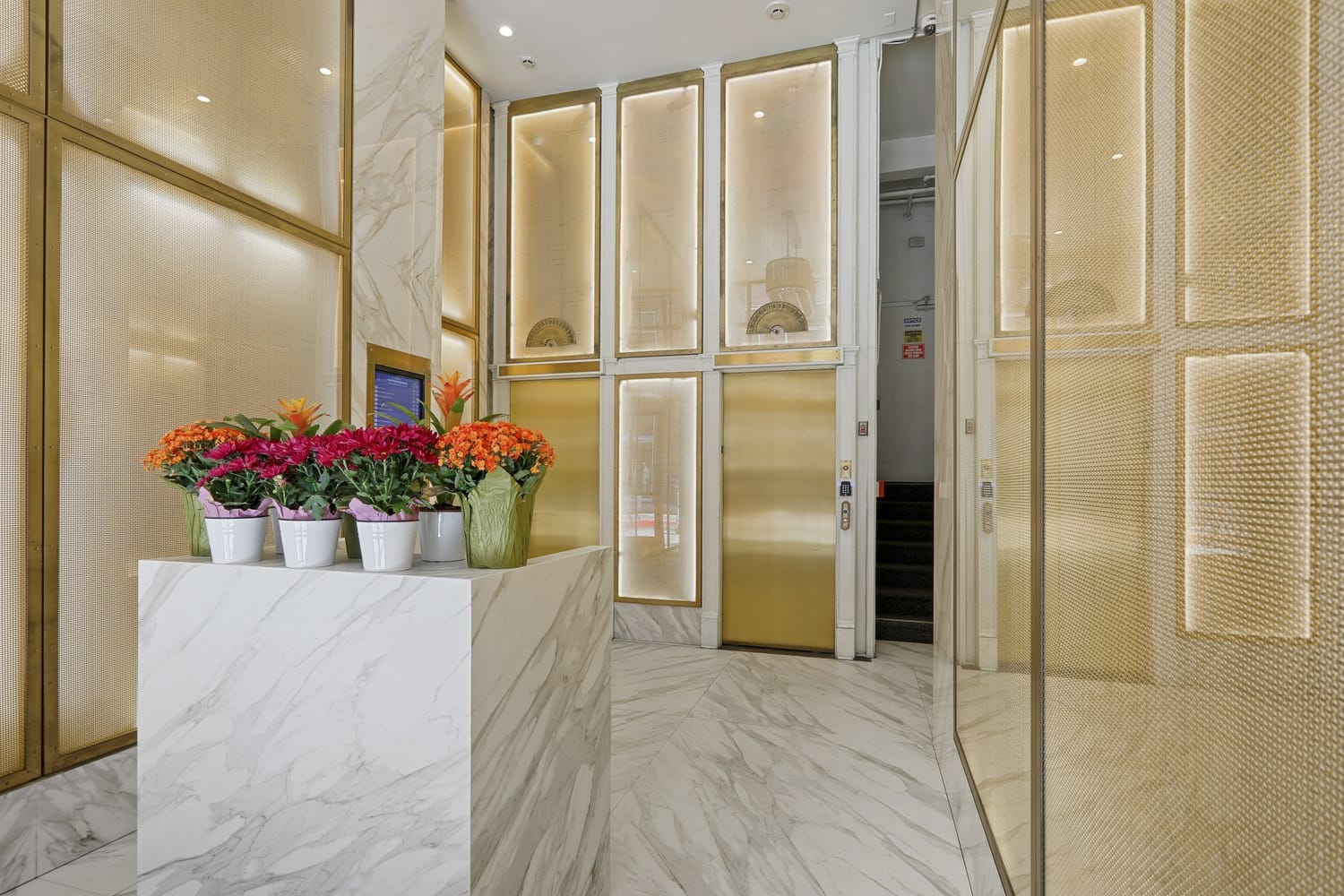 A grand hallway showcasing marble flooring and gold accents, found in the lobby area of 166 Geary in San Francisco.