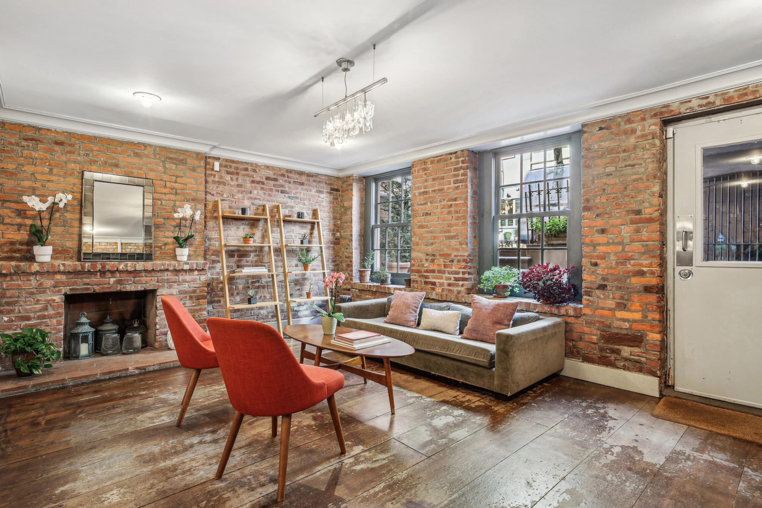 An inviting living room with rustic brick walls and a fireplace, ideal for hosting events at The Farm Soho venue.